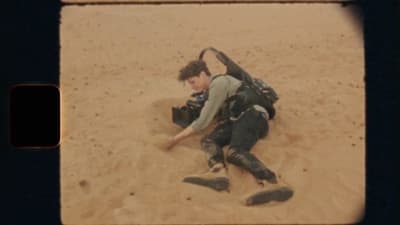 a person laying in the sand with a camera