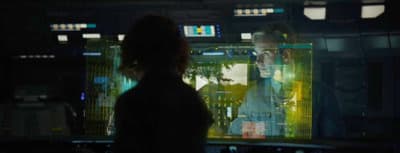 a woman standing in front of a computer screen