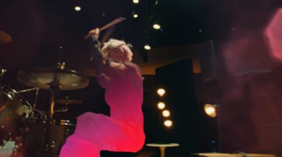 a woman in a pink dress is on stage