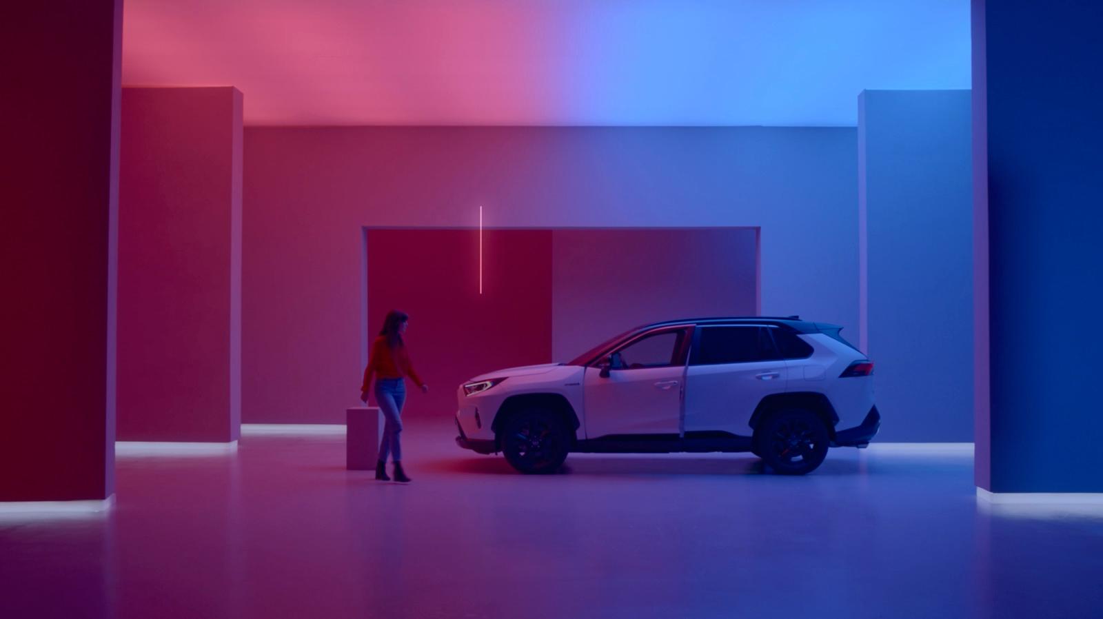 a woman standing next to a car in a room