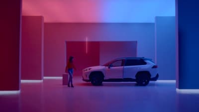 a woman standing next to a car in a room