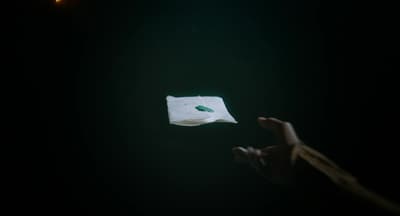 a person holding a piece of paper in the dark