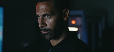 a man in a black shirt is staring at the camera