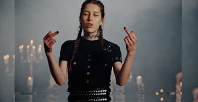a woman standing in front of candles with her hands in the air
