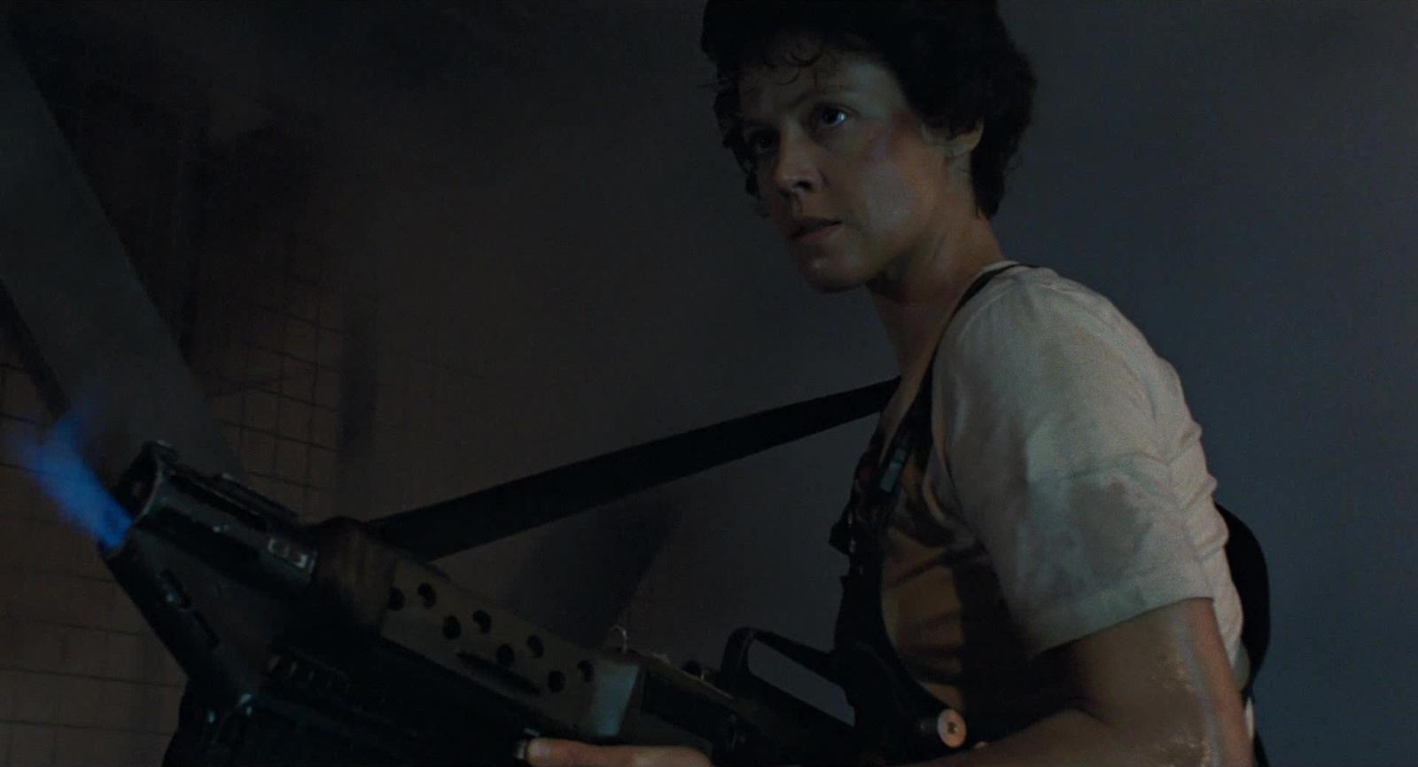 a man holding a machine gun in a dark room