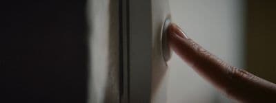 a hand pushing a button on a door