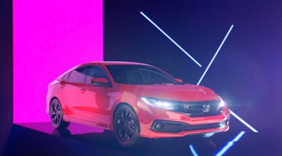 a red car is parked in front of a purple and pink wall