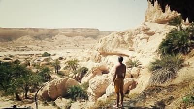 a man standing on a dirt road in the desert