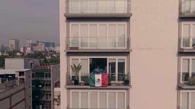 a person standing on the balcony of a tall building