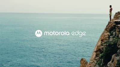 a man standing on top of a cliff next to the ocean