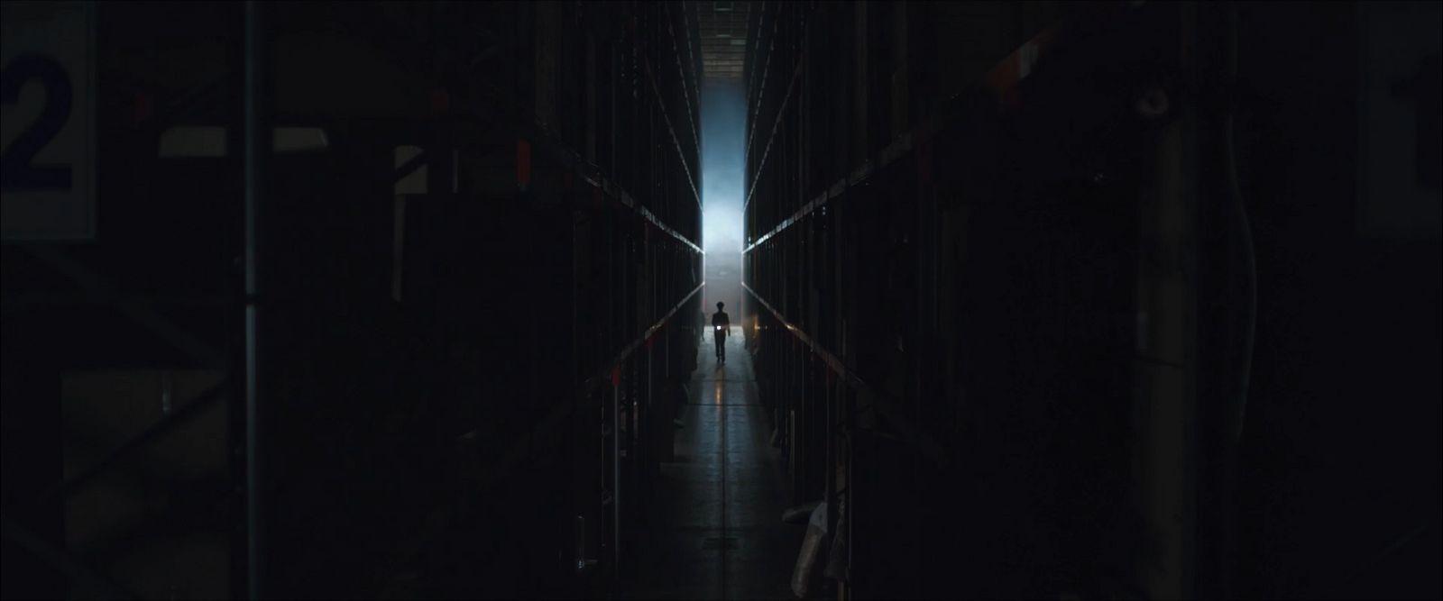 a dark hallway with people walking down it