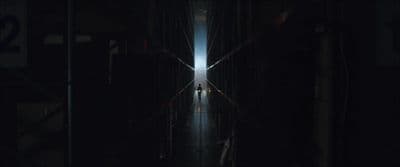 a dark hallway with people walking down it