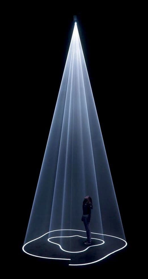 a person standing in front of a white light