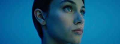 a close up of a woman's face with a blue background