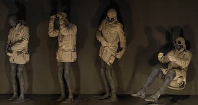 a group of statues of people standing next to each other