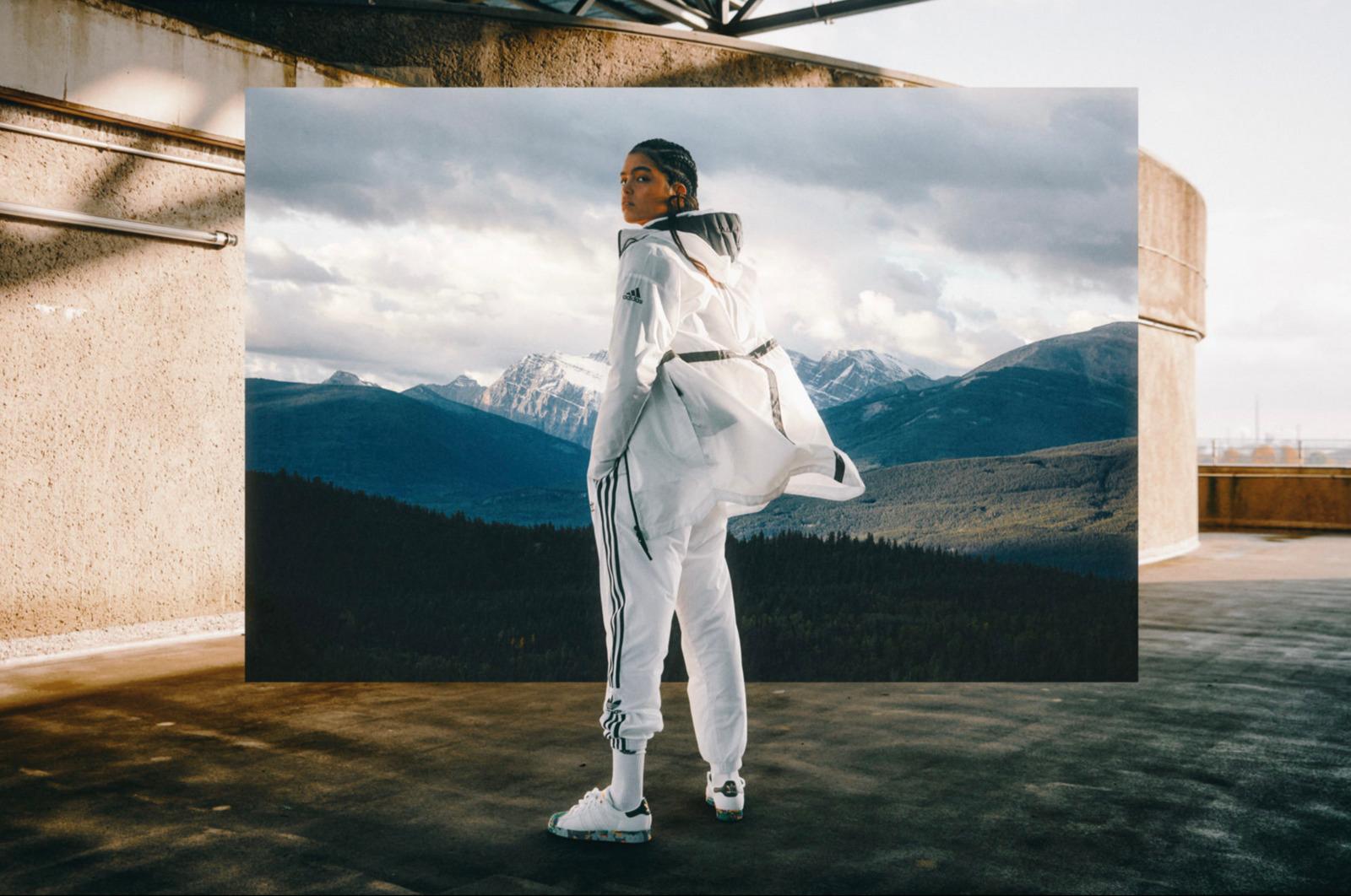 a woman standing in front of a picture of mountains