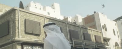 a person wearing a white veil standing in front of a building