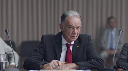 a man in a suit and tie sitting at a table