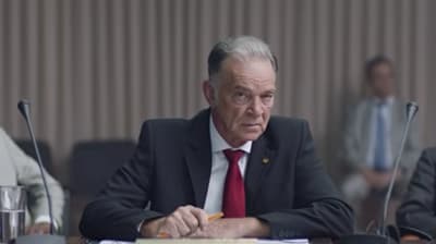 a man in a suit and tie sitting at a table