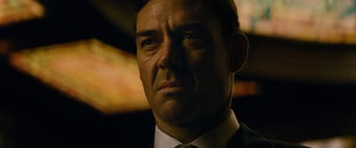 a close up of a person wearing a suit and tie