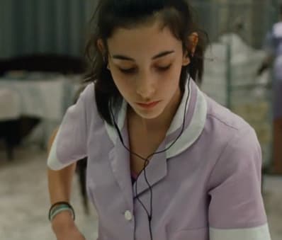 a young woman in a purple uniform is preparing food