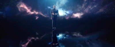 a man standing on a pole in the middle of the night