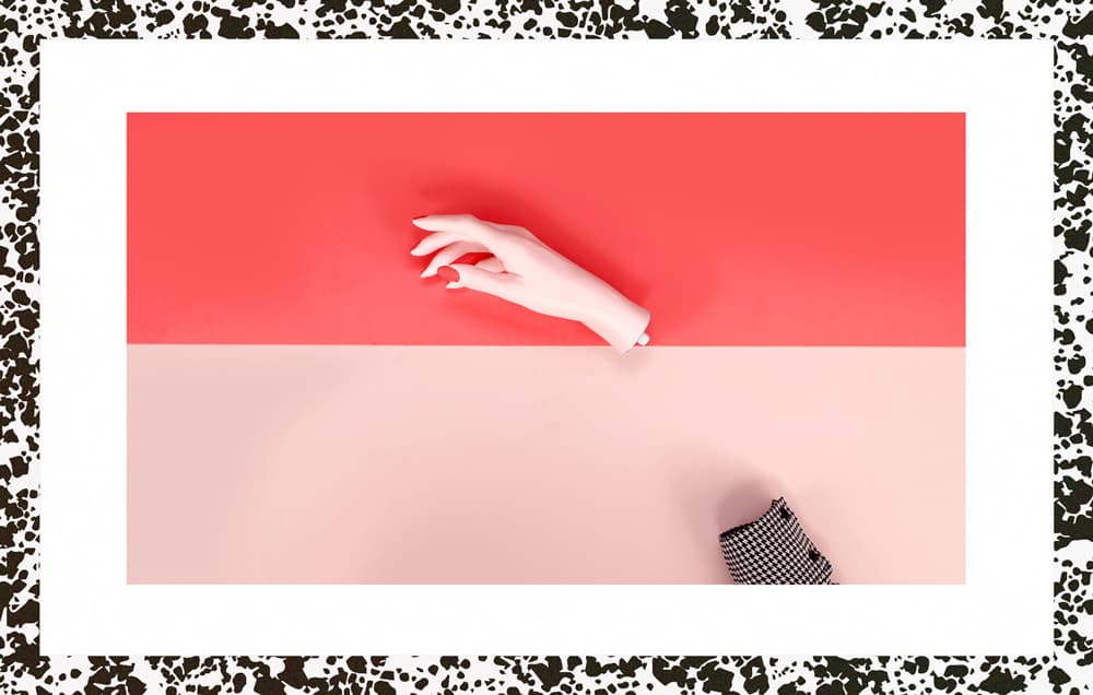 a person's hand on a red and pink background
