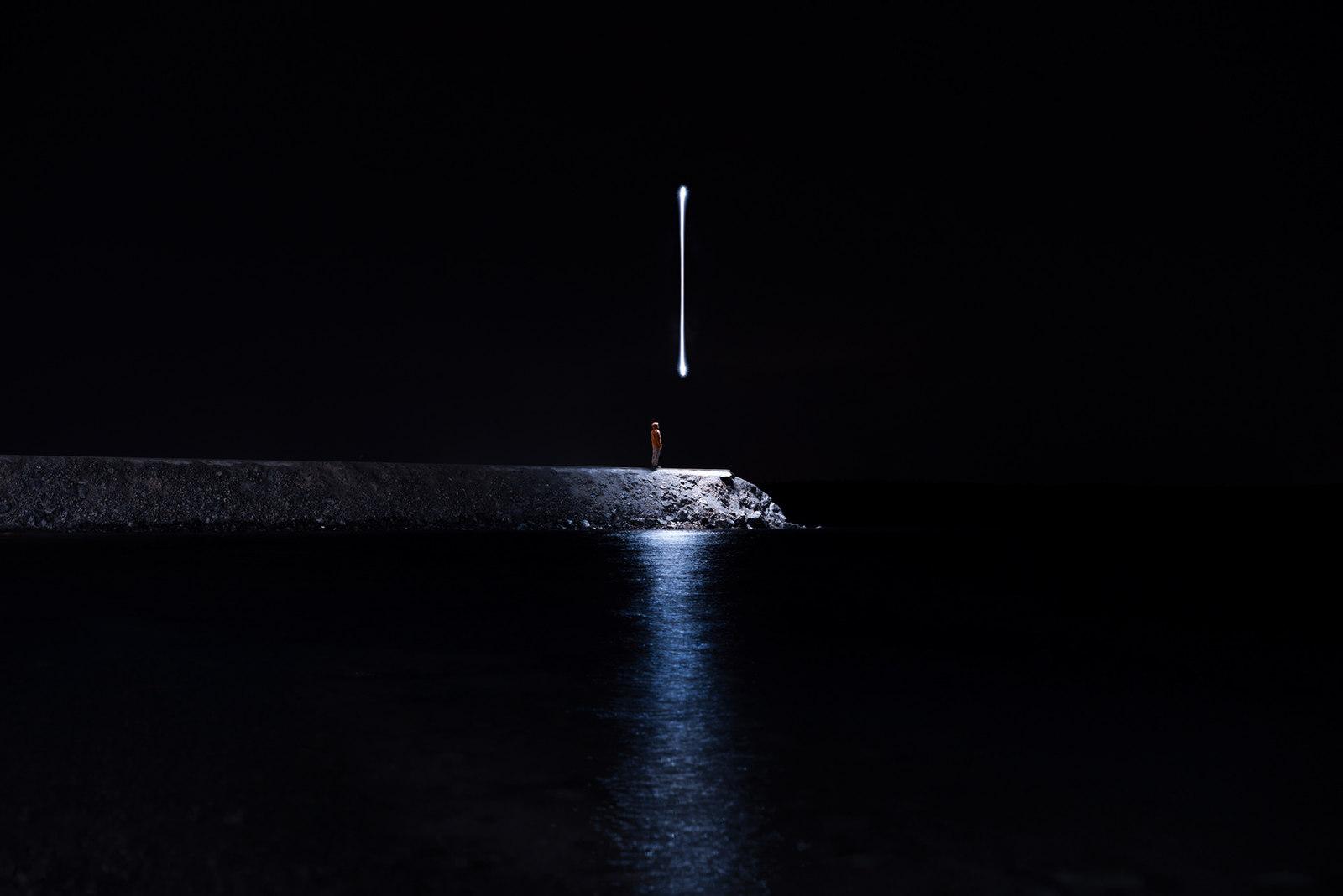 a person standing on a pier at night