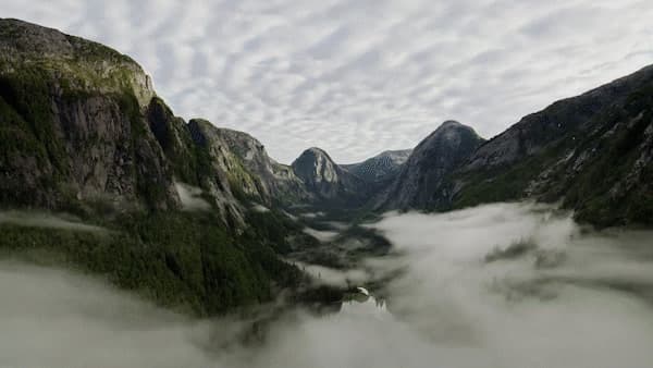 an aerial view of a valley with mountains in the background