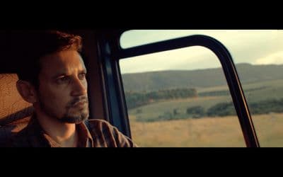 a man sitting in a vehicle looking out the window