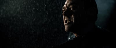 a man standing in the rain in the dark