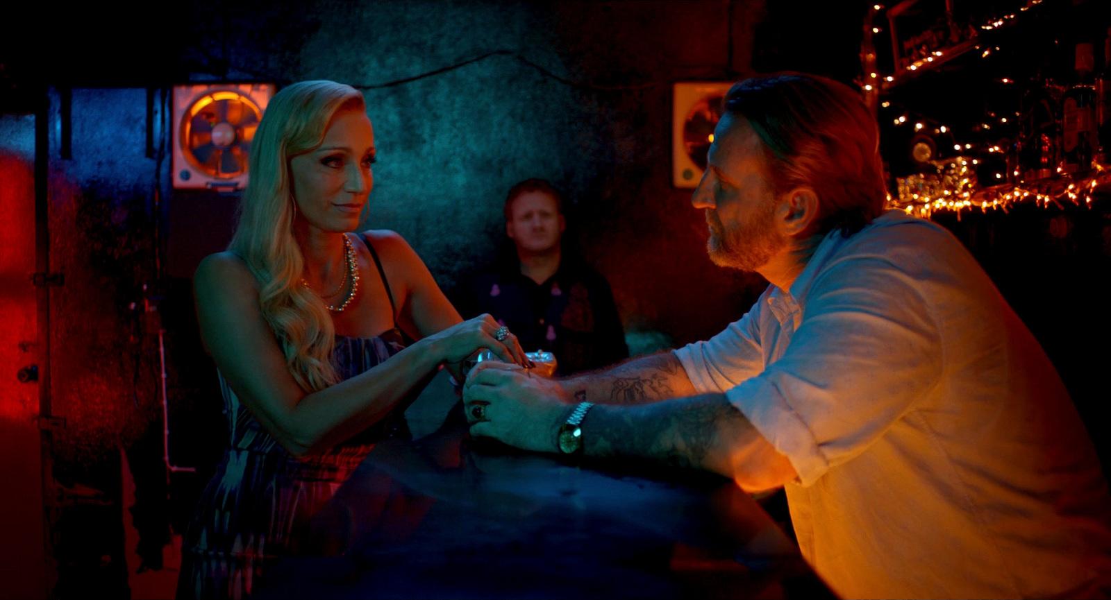 a man standing next to a woman in a bar