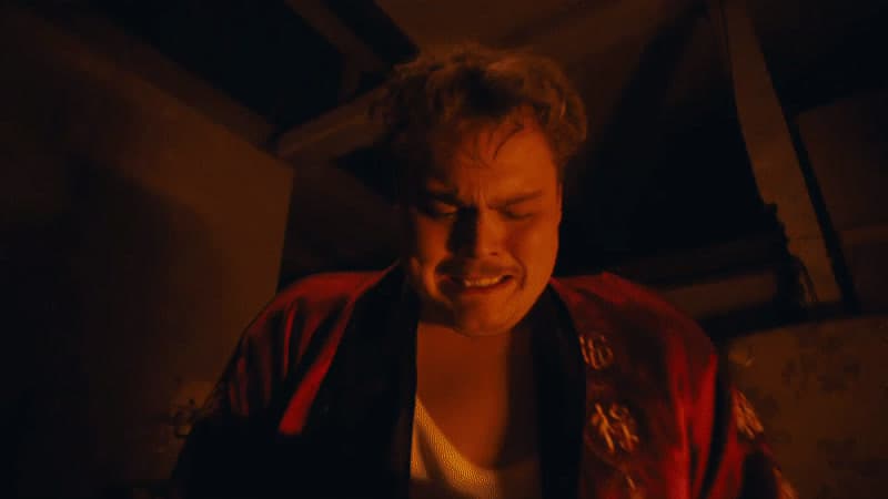 a man in a red jacket looking at a cell phone