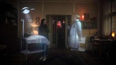 two people standing in a room with a light on