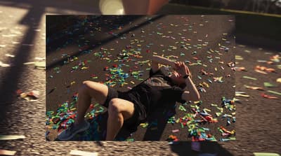 a man laying on the ground surrounded by confetti