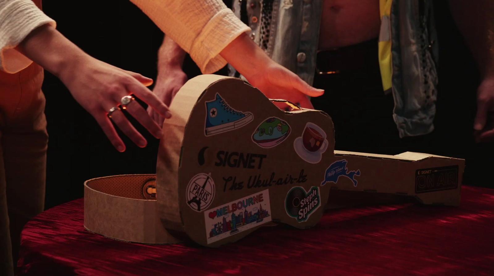 a group of people standing around a cardboard box