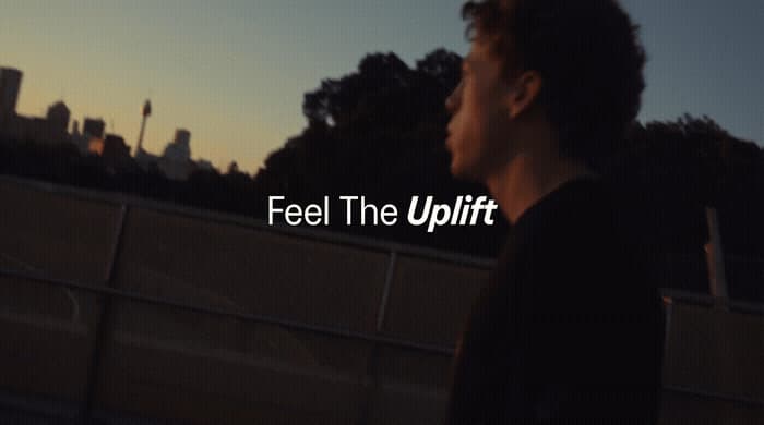 a man standing in front of a fence with the words feel the uplift