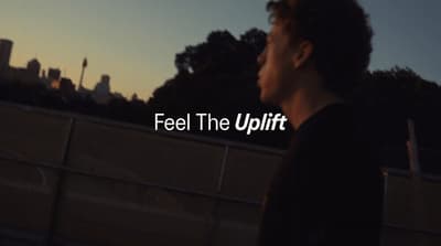 a man standing in front of a fence with the words feel the uplift