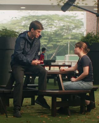 a man and a woman sitting at a picnic table
