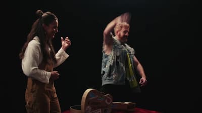 a woman standing next to a man on a stage