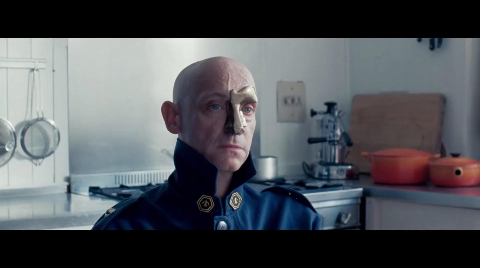 a man with a bald head in a kitchen