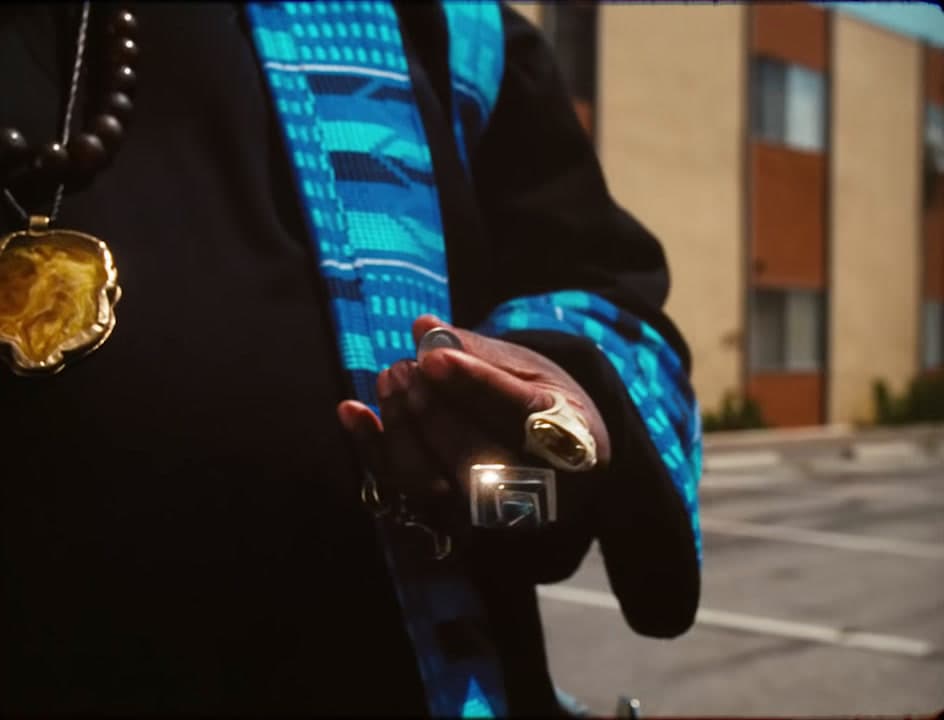 a person wearing a blue shirt and a gold necklace
