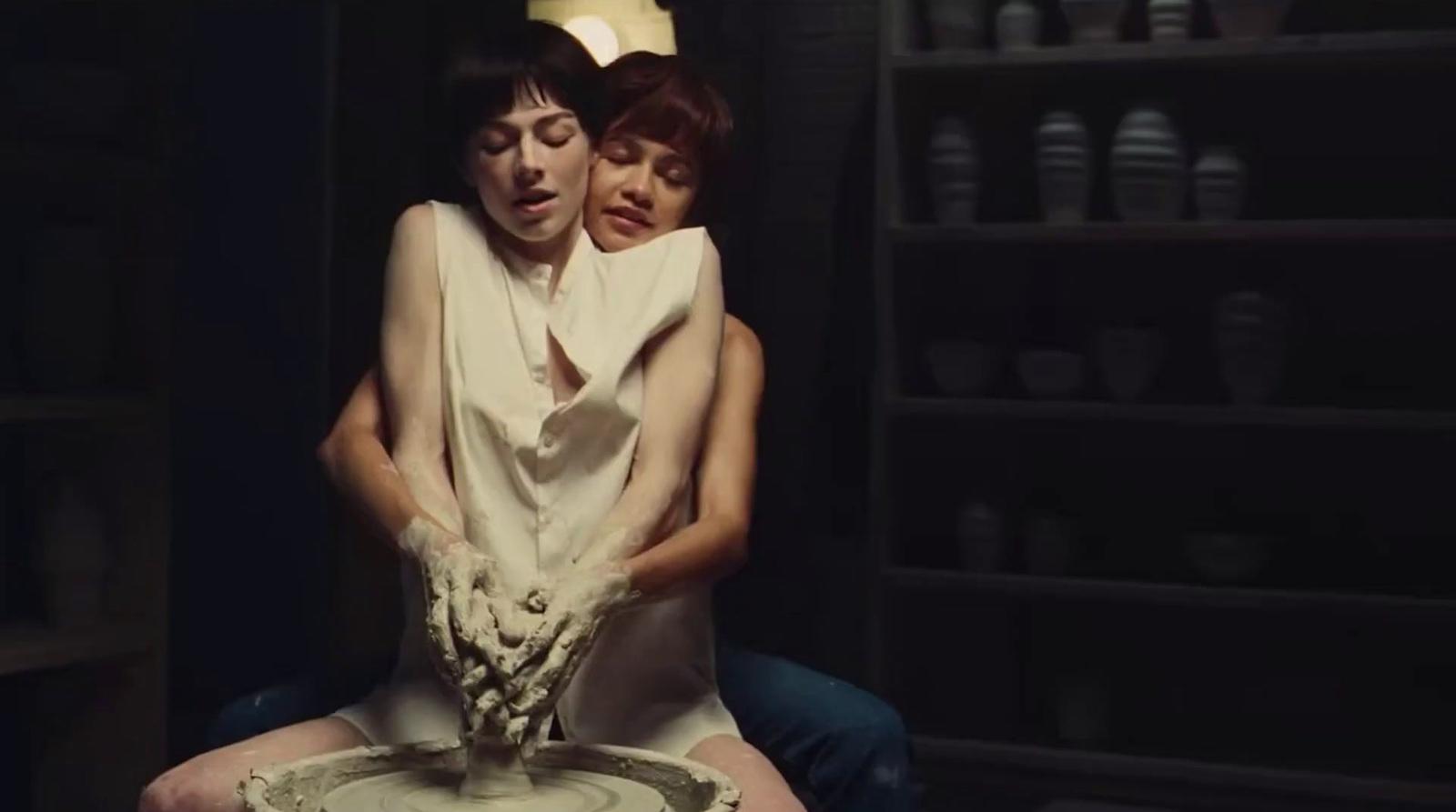 a woman sitting on a man's back in a dark room