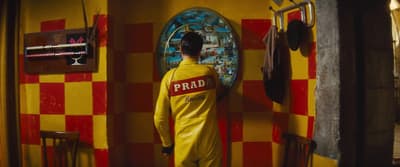 a man in a yellow suit standing in a room