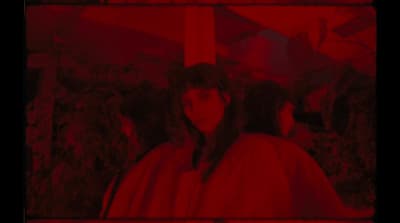 a woman standing in front of a red background