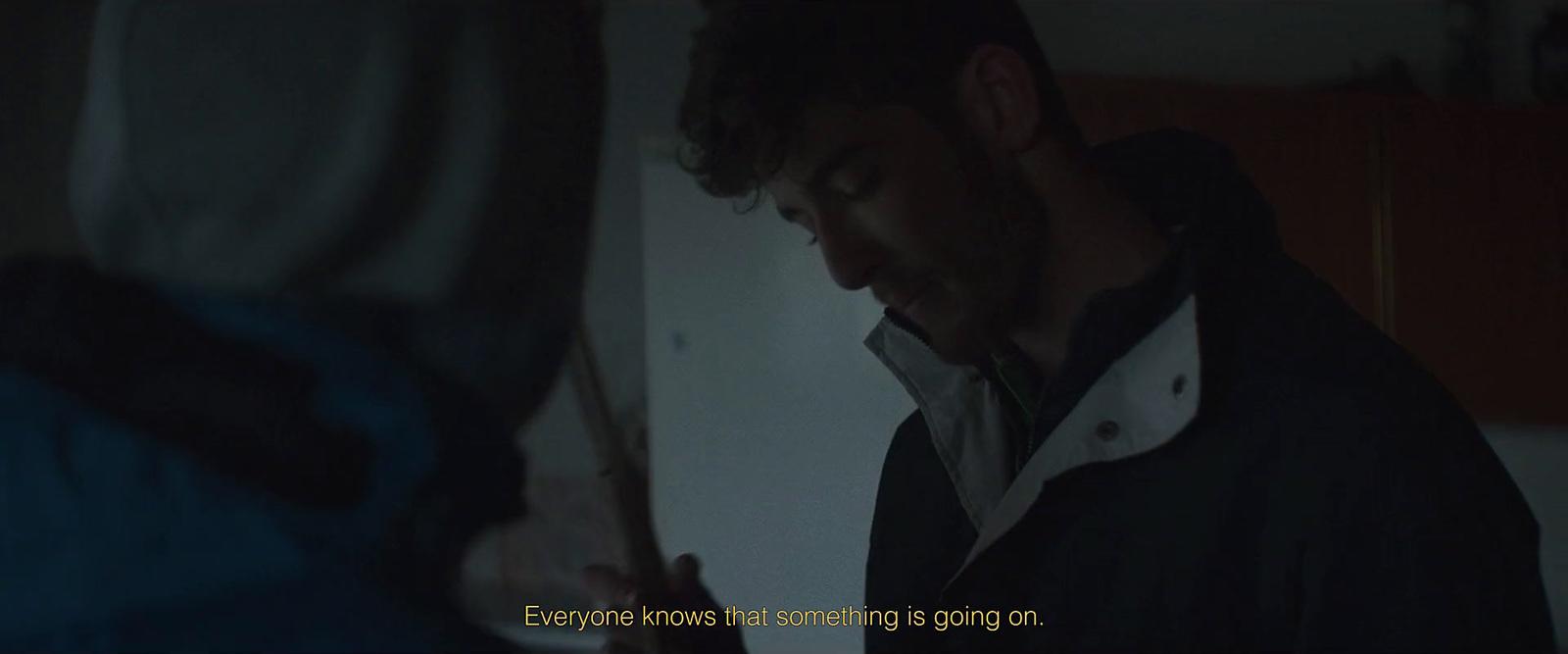 a man standing next to a woman in a dark room