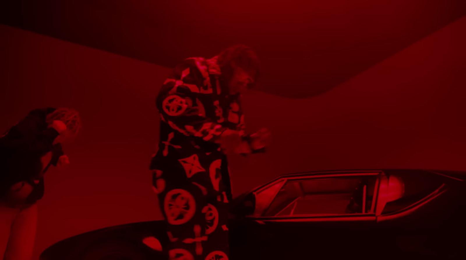 a man standing next to a car in a red room
