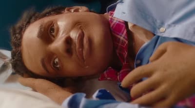 a man laying on a bed with his head on the pillow