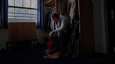 a man sitting on a stool in a room
