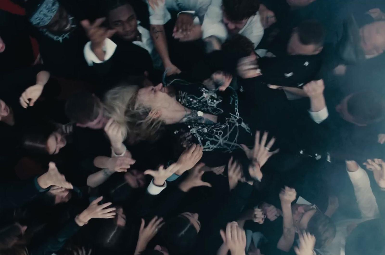a crowd of people with their hands in the air